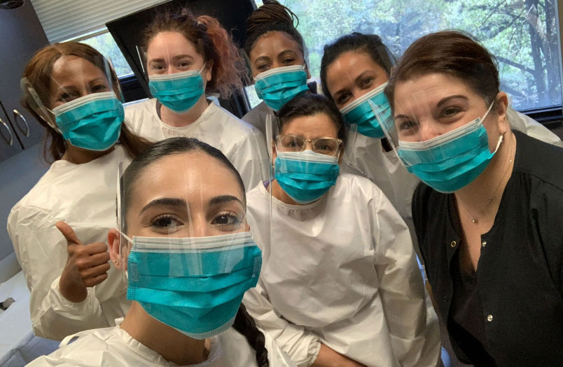 happy graduates of The Dental Assistant School of Rockland smiling under their medical masks